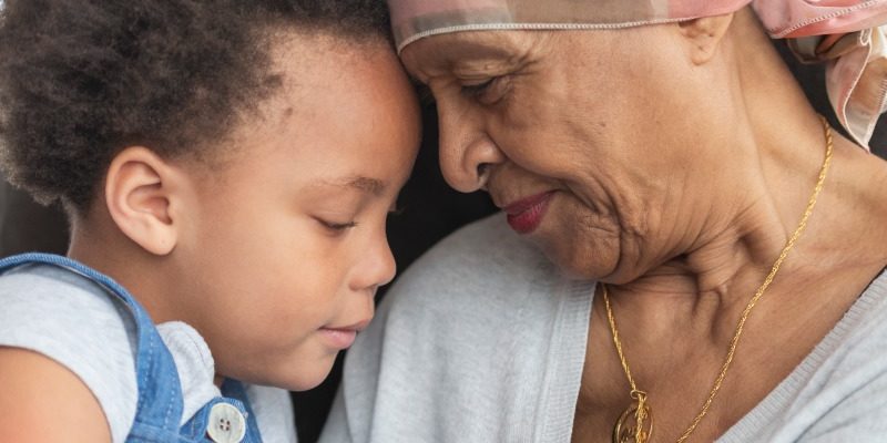 Senior woman with cancer hugging her grandchild