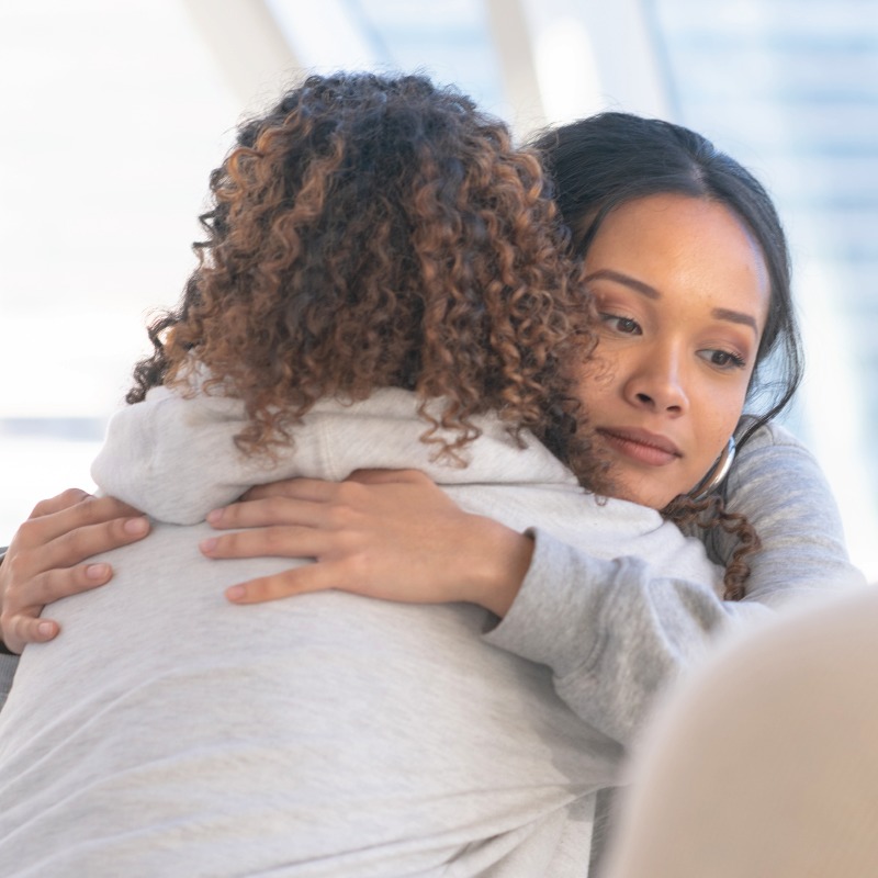 Young woman receiving a hug in support group